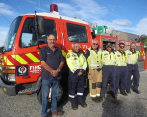 Former Omakau Fire Brigade chief Sam Leask, left, visits with the station firefighters during...