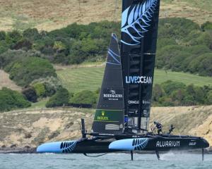 Andy Maloney, flight controller of New Zealand SailGP team, runs across the boat during a...