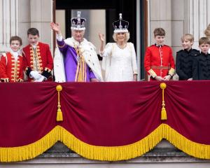 King Charles III and Queen Camilla wave from the balcony of Buckingham Palace following their...