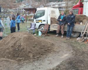 Volunteers wait patiently for the hangi to cook at the lakefront yesterday. PHOTO: REGAN HARRIS