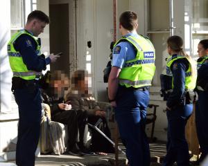 Police talk to boarding house residents after an alleged altercation. Photo: Stephen Jaquiery