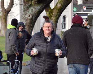 Janine Walker and her tiny "security" dog serve soup to the homeless at a caravan at the Oval...