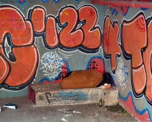 A homeless person sleeps in the basement of the Kaianga Ora building in Moray Place. PHOTO: STAFF...