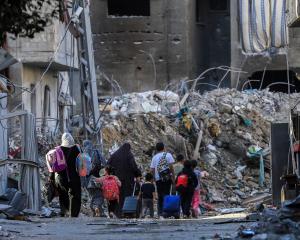 Palestinians carry their belongings as they flee homes in Gaza City. Photo: Reuters 