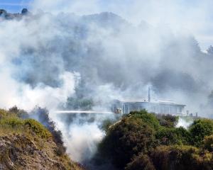 Fire fighters battle to extinguish a fire threatening a house on Test street in Oamaru. The fire...
