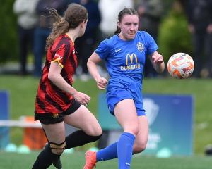 Southern United wing-back Freya Partridge-Moore taps the ball on under pressure from Ellerslie...