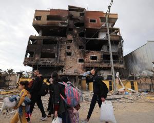 Palestinians fleeing the fighting in Gaza walk out of town as battles between Israel and Hamas...