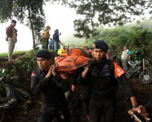 Police carry the body of a person killed in the eruption in West Sumatra province on Tuesday....