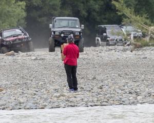 A protester from the Ashley Rakahuri Rivercare Group stands in front of 4WDs racing down the...