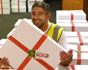 Christmas Box co-ordinator Jason Sargeant nestles among some of the completed boxes wrapped and...
