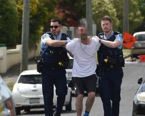 Armed police take a man into custody after an incident in Mitchell Ave on Friday morning. PHOTO:...