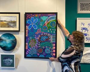 Otago Art Society publicity officer Jenny Longstaff adjusts a work in the popular "Love, Buy,...