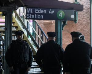 Members of the New York Police Department investigate the scene of a shooting at the Mount Eden...