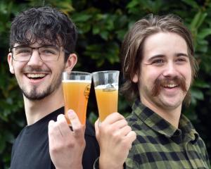 Callum Munro (left) and Ronnie Priestley, both 22, share a beer in Cargill St. Photo: Peter McIntosh