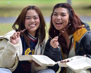 University of Otago students Noa Isip (left), 22, and Hanna Corre, 24, eat Philippine barbecue...