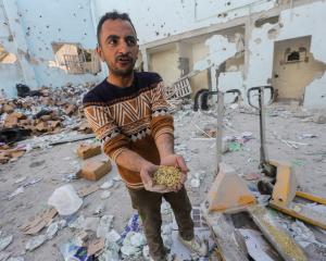 A Palestinian man at the site of an Israeli strike on an aid warehouse in Al-Nuseirat refugee...