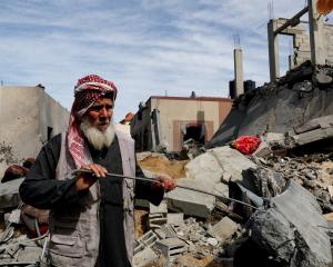 A Palestinian stands at the site of an Israeli strike on a house in Rafah in the southern Gaza...