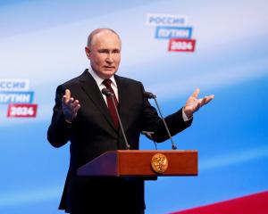 Vladimir Putin speaks at his election campaign headquarters after polling stations closed on the...