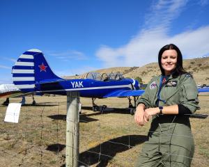 New Zealand Red Stars YAK-52 aerobatic team member Fay Emeny stands in front of one of her late...
