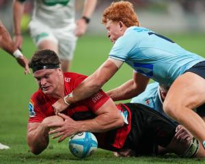 Tane Edmed of the Waratahs (right) tackles Crusader Scott Barrett to deny him try. Photo: Getty...