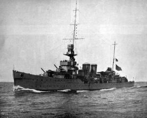 British light cruiser HMS Dunedin, pictured in fighting trim with all guns trained and cruising...