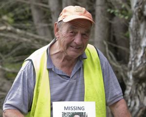 Murray Cumming, the stepfather of Jon Ellison, holds a missing persons poster in Bethunes Gully...