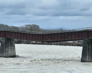 Flood waters have washed away one of the piers holding up the rail bridge over the Rangitata...