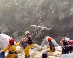Rescuers assist as a helicopter lifts an injured person on a stretcher Hualien on Thursday. Photo...
