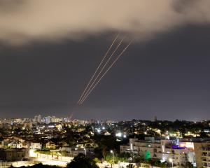 An anti-missile system operates after Iran launched drones and missiles towards Israel, as seen...