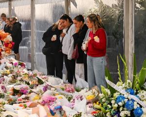 People view the floral tributes for victims of the stabbing attacks at the Westfield Bondi...