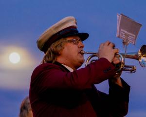 A bugler at the Oamaru dawn service is lit by the full moon this morning. Photo: Wyatt Ryder 
