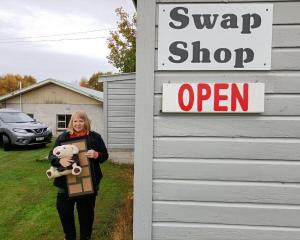 Owaka Swap Shop manager Annette Patterson holds swappable items outside the shop, as the team...