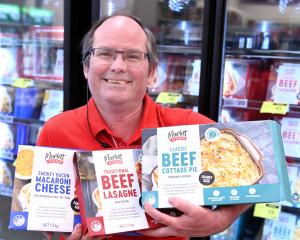 The Warehouse South Dunedin store manager Deon Nieuwoudt holds three Market Kitchen frozen ready...