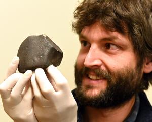 University of Otago geologist Dr Marshall Palmer holds a meteorite that was recently collected...