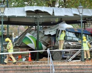 Firefighters assess the situation after a truck crashed in the Octagon, Dunedin, on Saturday...