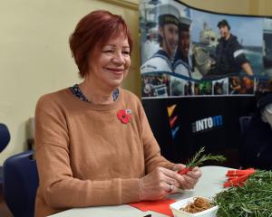 Volunteer Evelyn McDowall makes posies for Anzac Day, at HMNZS Toroa in Dunedin, yesterday. PHOTO...