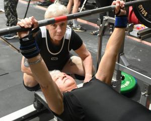 Nicola Atwool (70) warms up for her first weightlifting competition, spotted by partner Lesley...
