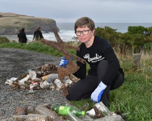 Dunedin volunteer Tracy MacAulay-Higgan holds up a rusted windscreen wiper found during the clean...
