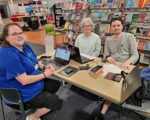 TechMate volunteers help resident with her laptop at Linwood library. PHOTO: SUPPLIED