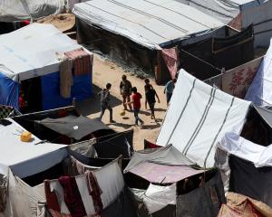 Displaced Palestinian boys play football as they shelter at a tent camp in central Gaza Strip on...