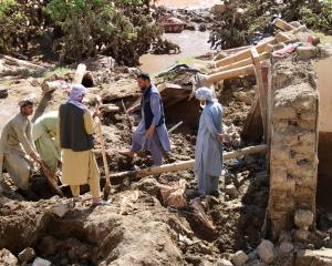 People remove debris from a flood-damaged house in Ghor Province, Afghanistan. Photo: Reuters