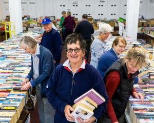 Bookarama volunteers sort through tens of thousands of books while Jacquie Webby carries a...