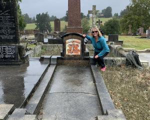 Christine Chisholm poses beside the graves of her great-grandparents Creighton Reid and Sarah...