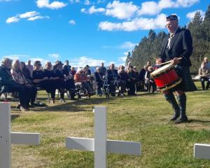 A drummer and bagpiper perform during the Oturehua Anzac service, in front of about 40 people....