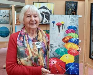 Holding her oil painting of umbrellas called It’s Raining Again is Norma Parks, of Tapanui. The...