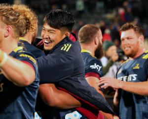 Highlanders loose forward Kazuki Himeno hugs team-mates after the win over the Crusaders in...