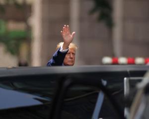 Donald Trump gestures to people outside Trump Tower in New York the day after being found guilty...