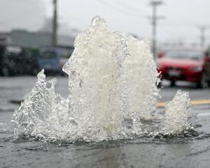 Water springs up from a manhole cover at the bottom of Blacks Rd, North East Valley. PHOTO:...
