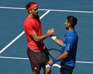 Novak Djokovic (right) of Serbia shakes hands with Alexander Zverev of Germany shake hands...