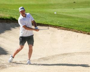 Richie McCaw chips out of a bunker during practice for the New Zealand Open at Millbrook Resort...